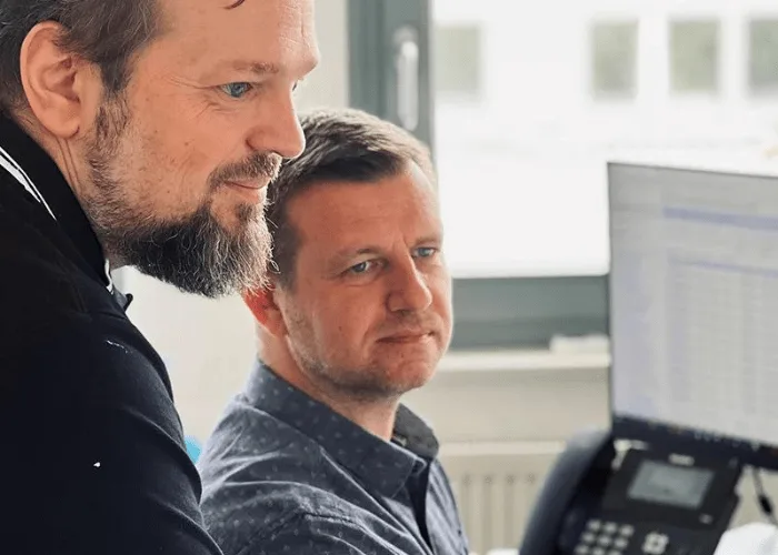 Zwei Kollegen der DECOR-UNION besprechen Auswertungen am Bildschirm