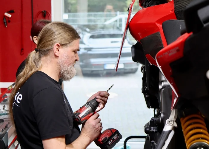 Mechatroniker von Niederrhein Moto schraubt an einem Motorrad
