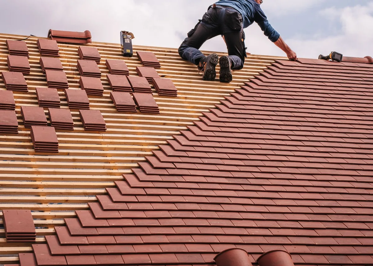 Dachdecker beim Eindecken eines Steildachs