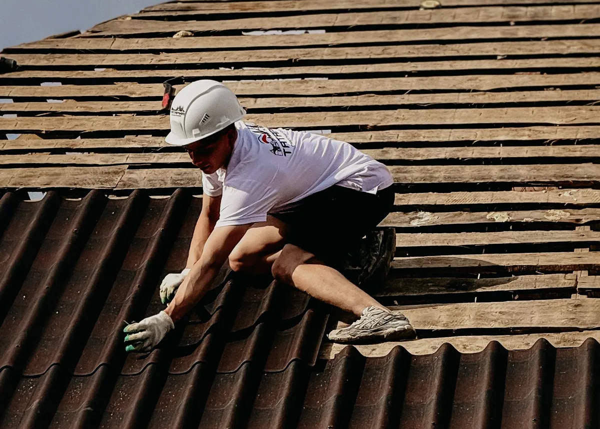 Dachdecker mit Helm beim Eindecken